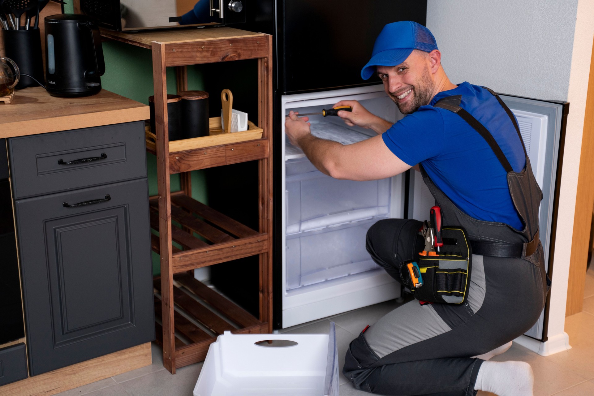 An electrical technician working on the repair of a refrigerator or refrigeration equipment