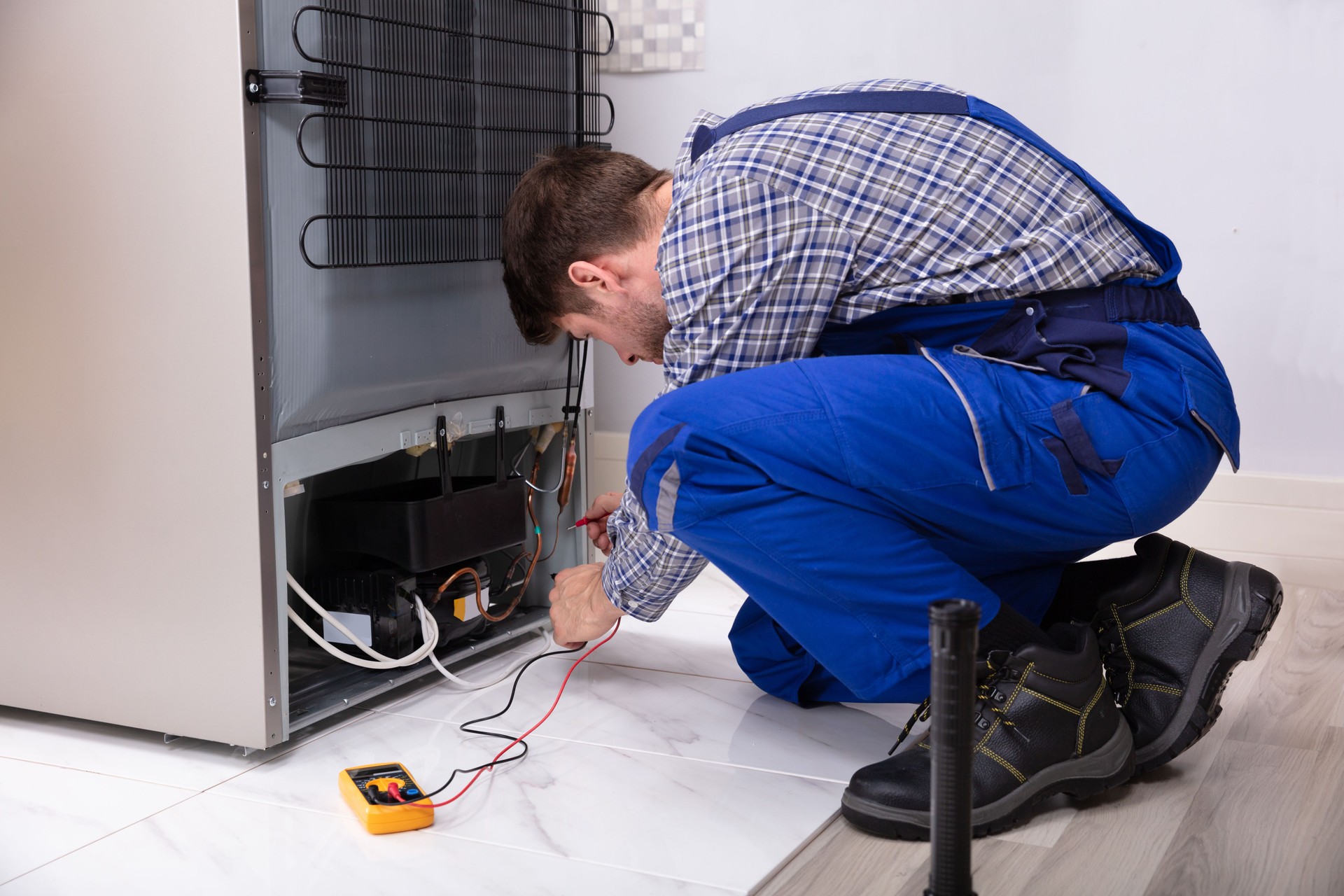 Mr harish Repairman Checking Fridge With Digital Multimeter